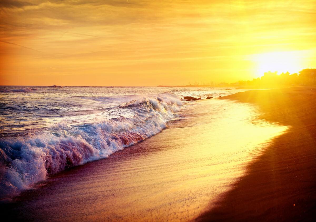 Глядя вдоль пляжа. Океан разрывается с левой стороны - солнце садится справа